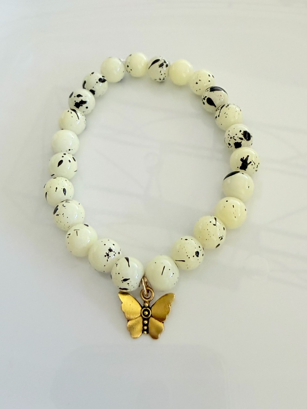 Speckled White Bead Bracelet with Gold Butterfly Charm